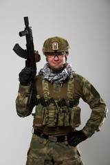 Portrait of soldier in safety glasses with gun in his hand