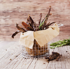 jerked meat, cow, deer, wild beast or biltong in kraft paper bowls on a rustic table, selective...