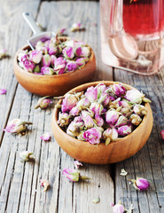 small dry buds of roses, tea, karkade, in wooden bowls, selective focus