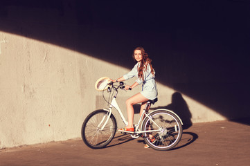 Fototapeta na wymiar Urban biking - young woman and bike in city