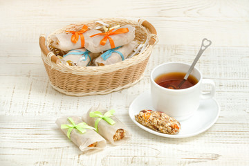 Mug of tea and muesli bar. Wicker basket with bars