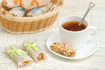 Cup of tea and a bar of muesli. Wicker basket in the background