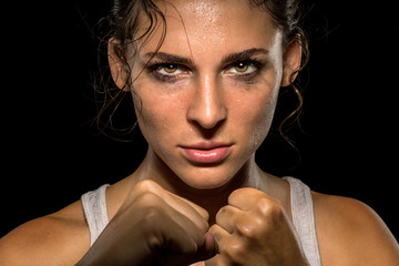 Intense female fighter stare with fist up in self defense training, powerful and confident - obrazy, fototapety, plakaty