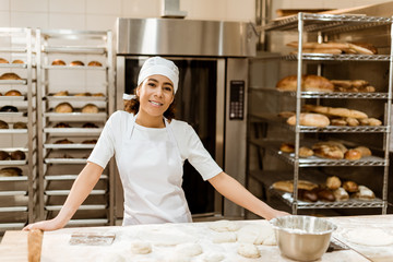 female baker standing at workplace on baking manufacture