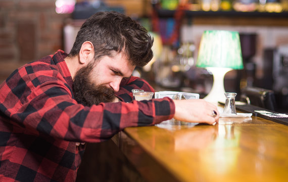 Man with tired face sit alone at bar counter