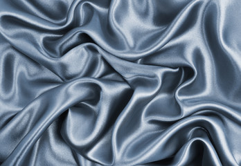 Smooth elegant dark grey silk or satin texture as abstract background. Luxurious background design