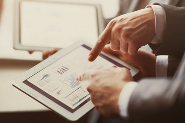 Hands of people working with tablet computer in office. Technology.