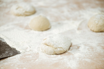 Fototapeta na wymiar close-up shot of dough ball on table spilled with flour