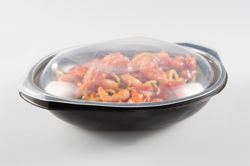 Salad in plastic container on white