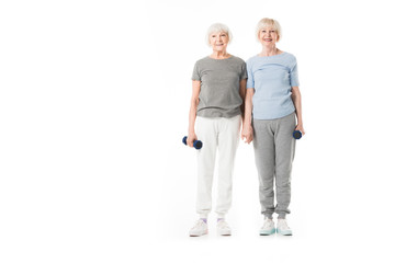 Two senior sportswomen with dumbbell in hand isolated on white