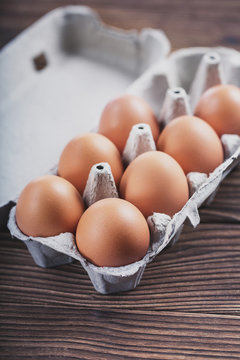 Close-up of raw chicken eggs in a box. Eggs on an old wooden table