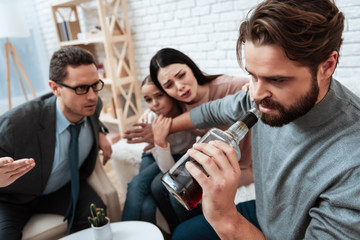 Bearded father is alcoholic with frustrated wife and daughter at psychologist's reception.