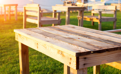 Fototapeta premium Morning. Empty wooden tables and chairs in the park.