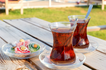 Cup of black Turkish tea and traditional asian sweets.