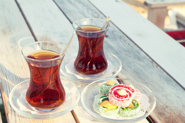 Cup of black Turkish tea and traditional asian sweets.