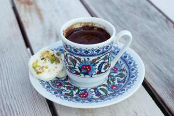 Cup hot black Turkish coffee and traditional sweets.