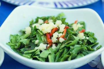 Salad with fresh peppers, tomatoes, cheese and green leaves.