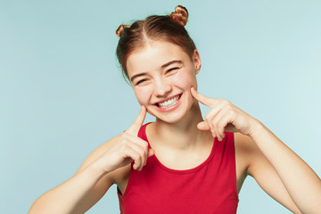 Woman smiling with perfect smile on the blue studio background