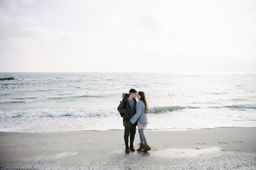 young couple hugging on winter seashore