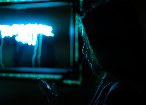 Silhouette Of A Girl Looking At A Mobile Phone