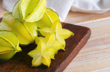 Exotic  starfruit  or carambola on wooden cut board. Healthy food, fresh organic star apple fruit. Carambolas background