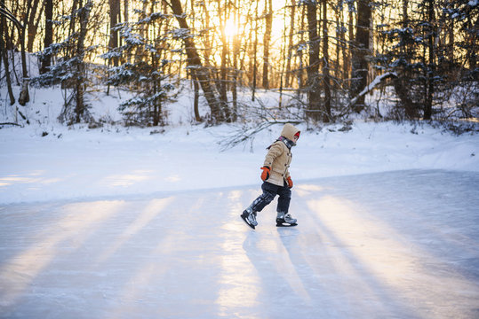 Boy ice-skating on a frozen lake