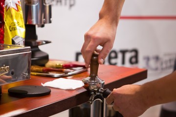 Barista hands cooking delicious and aromatic coffee on a table at a coffee machine, shallow dof photo