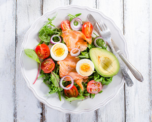 Smoked salmon salad with greens, tomatoes, eggs and avocado