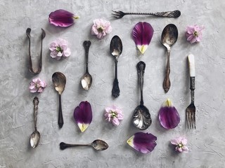 Antique silver cutlery, flower heads and flower petals