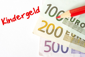 Euro Geldscheine, ein roter Malstift und Kindergeld