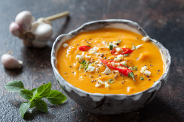 Roasted pumpkin and carrot soup with cream and pumpkin seeds