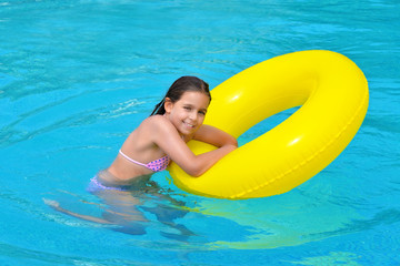 Real adorable girl relaxing in swimming pool