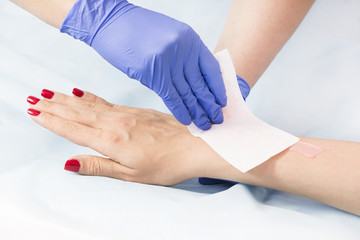 The process of classical wax depilation of female limbs in the beauty salon. 
