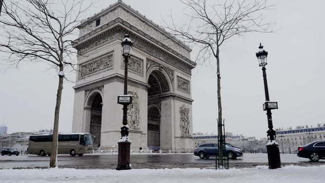 The arc de triumph by a rare snowy day in Paris, France