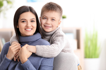 Young woman with little boy indoors. Child adoption