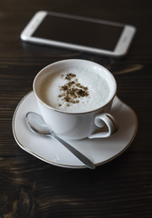 Cup of coffee and phone on the table.