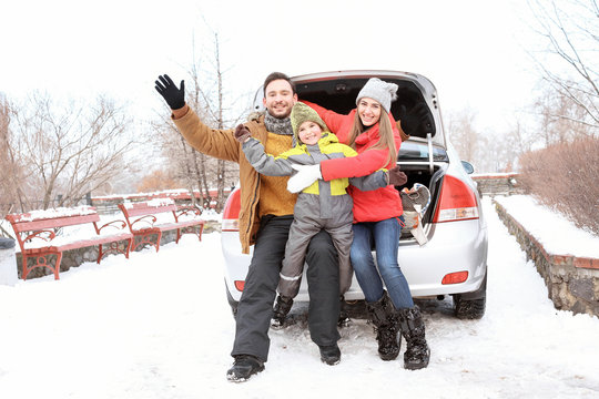 Happy Family Sitting In Car Trunk On Winter Vacation