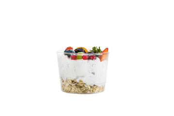 Creamy cream dessert in a plastic cup decorated with berries on a white background. 