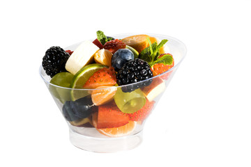 Fruit salad with bananas, strawberries, berries, in plastic utensils on a white background.