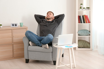 Young man resting in armchair at home