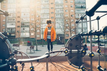 Little boy playing in the balance bar in a playground