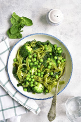 Spinach pasta primavera with green vegetables (broccoli, sweet pea and spinach).Top view.