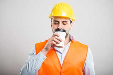 Portrait of architect smelling takeaway coffee cup
