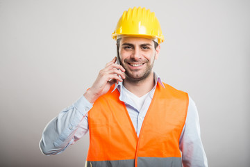 Portrait of young architect talking at smartphone