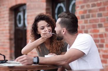 Young couple enjoying coffee at a street cafe and  laughing