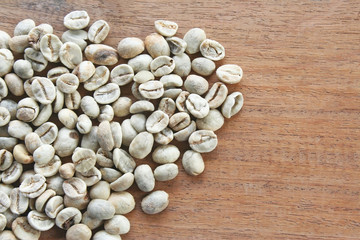 Many fresh raw coffee on wood table background