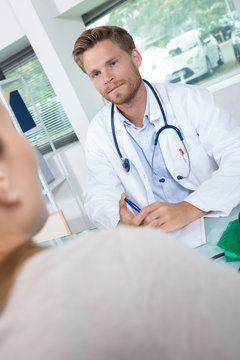 doctor listening to female patient