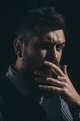 Bearded macho with cigar. Gentleman in checkered shirt and waistcoat smoking cigar. Elegant man with beard, mustache smoke cigar. Classical vintage male portrait. Bearded man in stylish retro clothes.