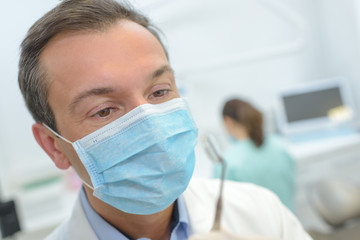 male dentist in a room with medical equipment