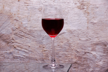 A photo of a glass of Expensive red wine taken in the basement